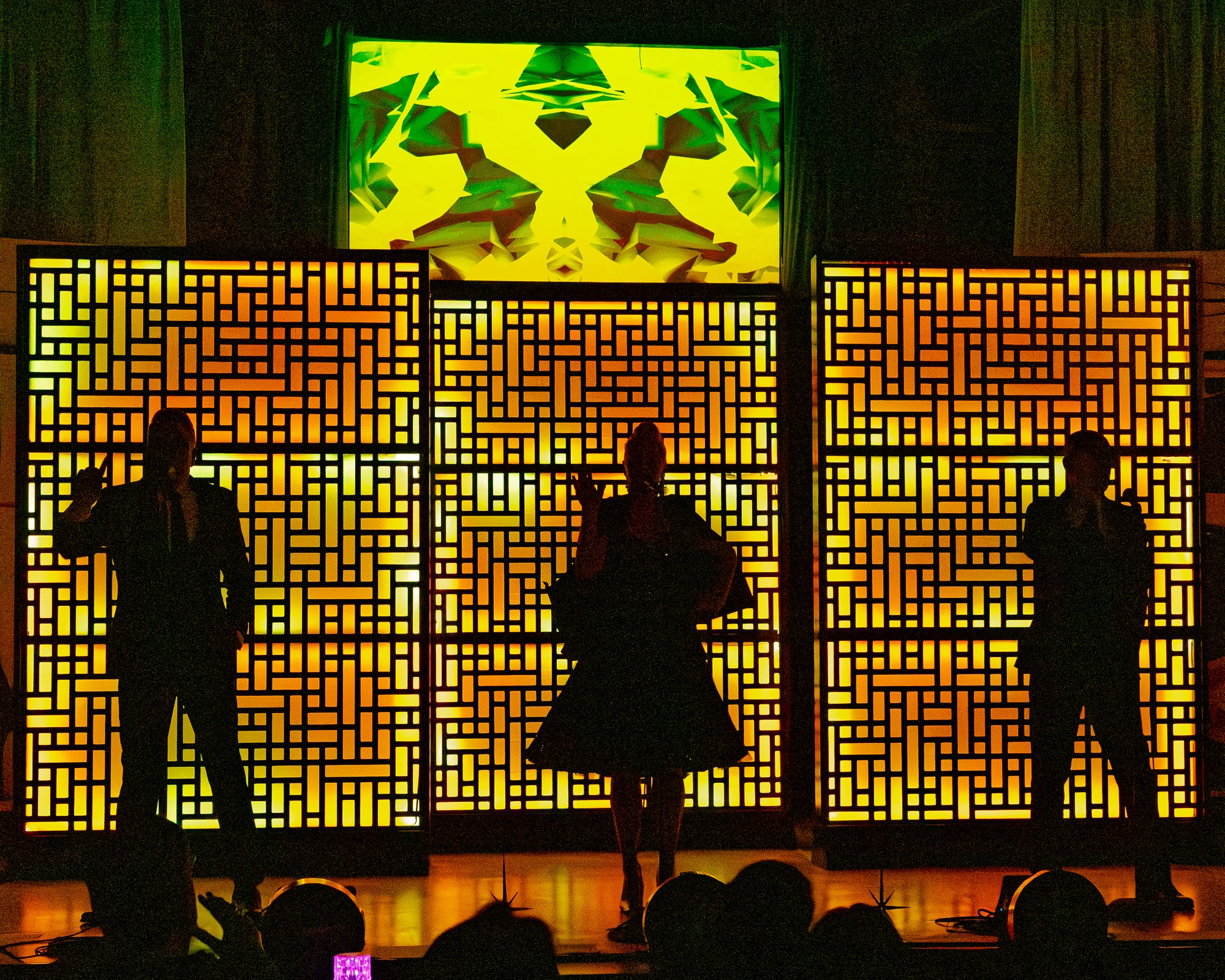 The Fabulous Lounge Swingers — three performers silhouetted against illuminated geometric panels