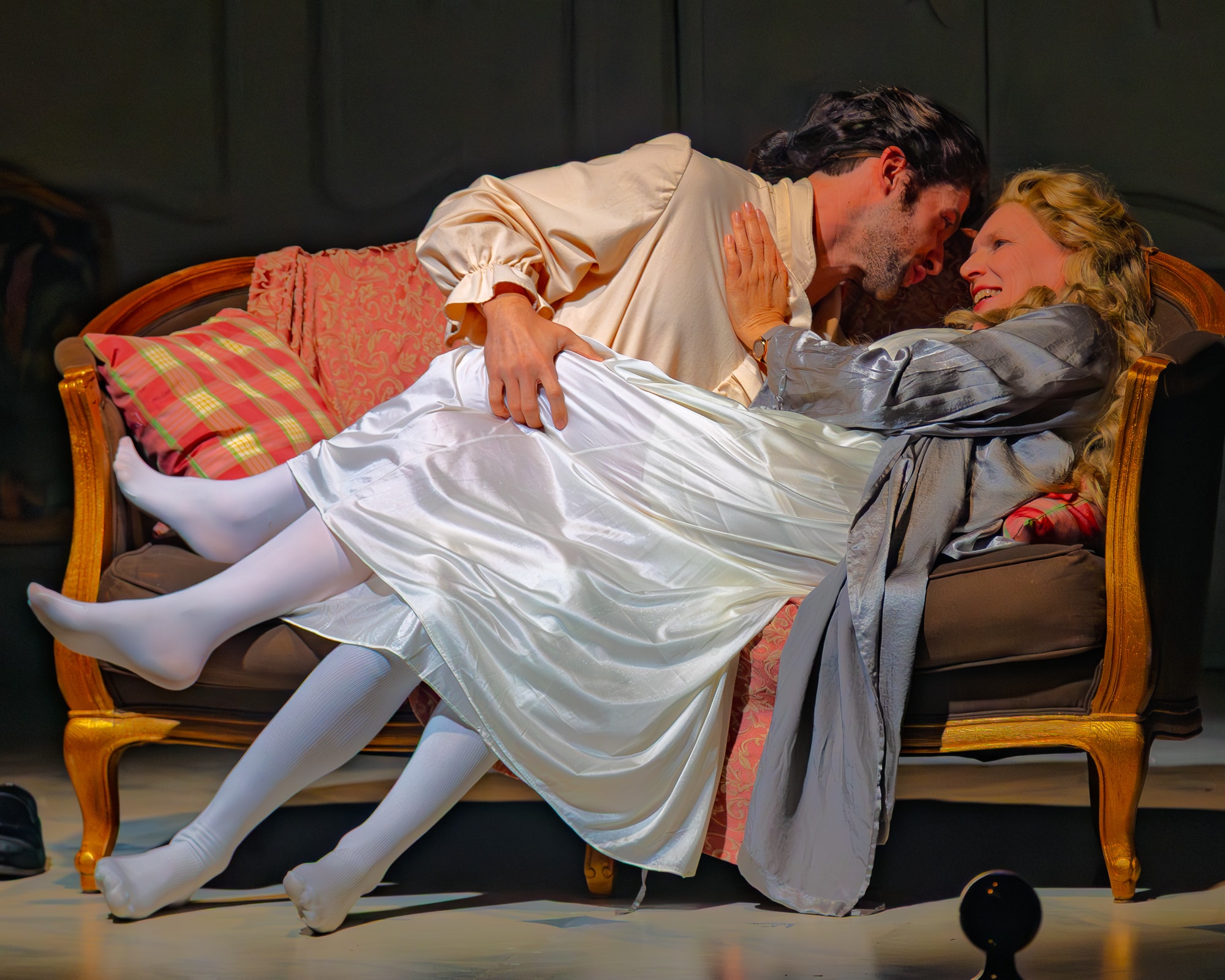 Legacy of Light 2025 — theatrical actors embracing on ornate sofa